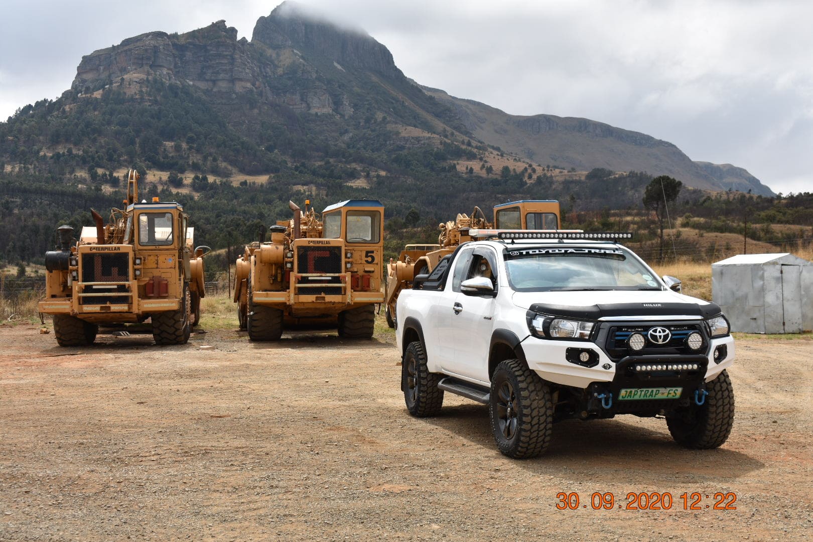 A Fleet of Caterpillar 621B Scrapers with a Hilux in front